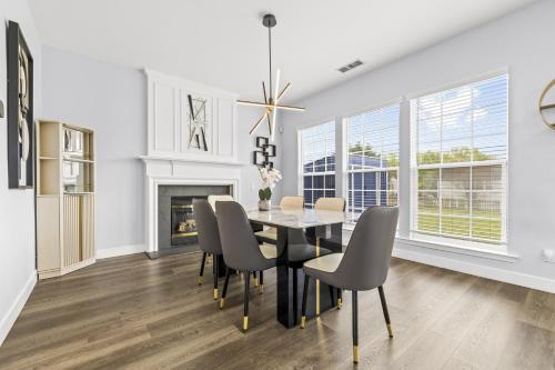 a dining room with a table and chairs and a fireplace at 3BR Family Retreat with Modern Comforts in Charlotte