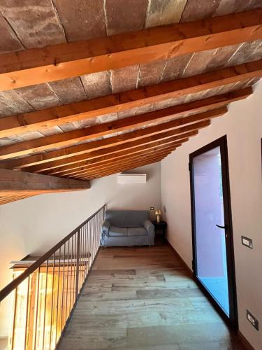 a living room with wooden ceilings and a couch at The Barn among olive trees in Ponte a Ema