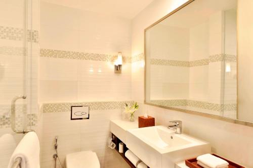 a white bathroom with a sink and a mirror at Fairfield by Marriott Amritsar in Amritsar