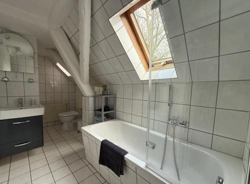 ワイマールにあるFerienapartment Weimar Altstadt 2の浴槽と洗面台と窓のあるバスルーム
