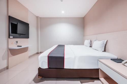 a hotel room with a bed and a tv at Collection O Hotel Igloo in Bekasi