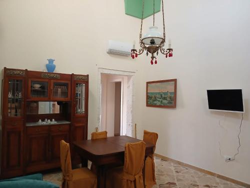 a dining room with a table and chairs and a chandelier at Palazzo delle favole in Ostuni