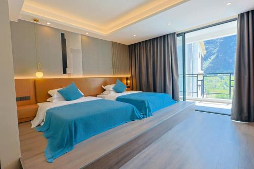 a bedroom with two beds and a large window at Yangshuo-Greenery Retreat in Yangshuo