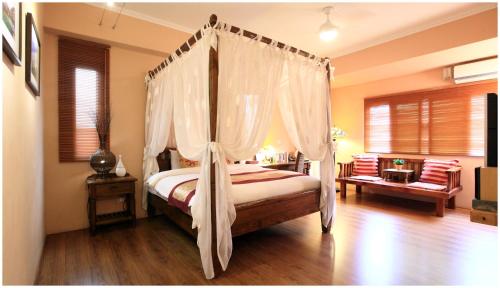 a bedroom with a canopy bed with curtains at Errantry Lodge & Studio in Hualien City