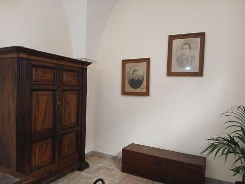 a room with a cabinet and two pictures on the wall at Palazzo delle favole in Ostuni