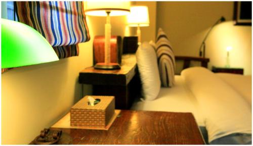 a bedroom with a bed and a table with a night stand at Errantry Lodge & Studio in Hualien City