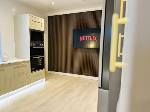 a kitchen with a netflix sign on a wall at Red Roofs - 5BR Luxury - Large Gardens - EV Point - Near Edinburgh in Newtongrange