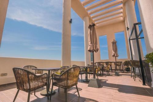 a patio with tables and chairs and umbrellas at La Privé Apartments TRI-ZEN in Colombo