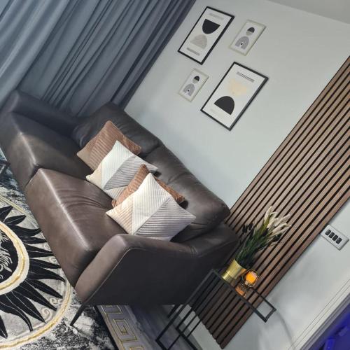 a living room with a leather chair with pillows at Unique Penthouse with Jacuzzi & Garden in Birmingham