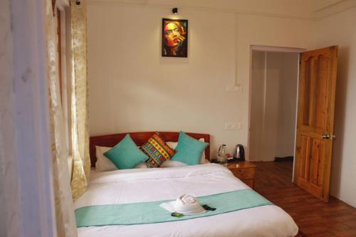 a bedroom with a bed with a hat on it at Mana Hills Farmstay in Mangpu