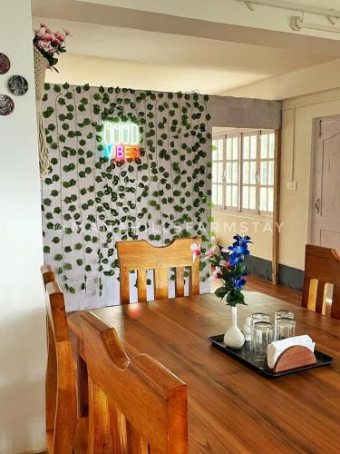 a dining room with a wooden table with a sign on the wall at Mana Hills Farmstay in Mangpu