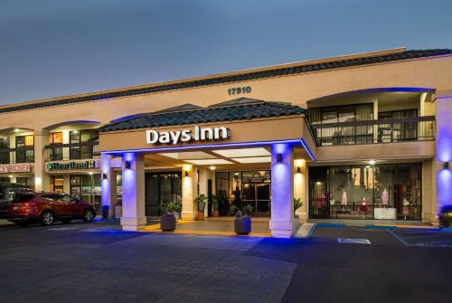 a day inn sign on the front of a building at Days Inn & Suites by Wyndham Artesia in Artesia