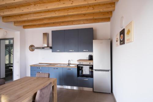 a kitchen with blue cabinets and a wooden table at HARMONIC Residence in Bergamo