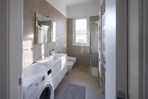 a white bathroom with a sink and a toilet at HARMONIC Residence in Bergamo
