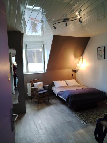 une chambre avec un lit et une chaise dans une pièce dans l'établissement studio Berck Plage d'Opale, à Berck-sur-Mer