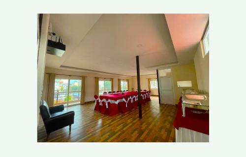 a large room with a table with red chairs at Hotel Juju in Pokhara