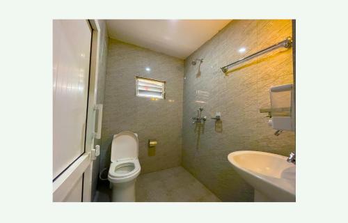 a bathroom with a toilet and a sink at Hotel Juju in Pokhara