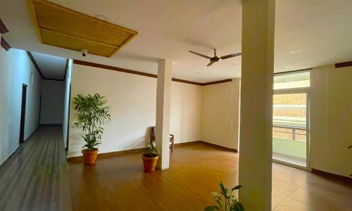 an empty room with potted plants and a ceiling at Hotel Juju in Pokhara