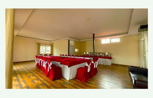 a banquet hall with red and white tables and chairs at Hotel Juju in Pokhara