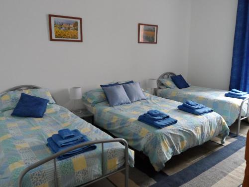 2 posti letto in una camera con asciugamani blu di Chez Beaumont - Gite a Saint-Sébastien