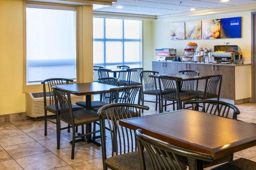 a dining room with tables and chairs in a restaurant at Comfort Inn & Suites in Moose Jaw