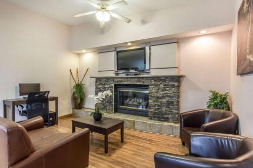 a living room with a fireplace and a tv at Econo Lodge Inn & Suites in Lethbridge