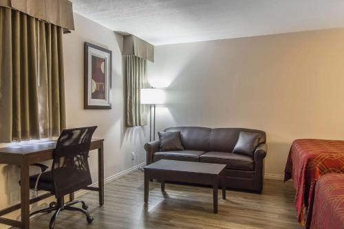 a hotel room with a couch and a desk and a bed at Econo Lodge Inn & Suites in Lethbridge