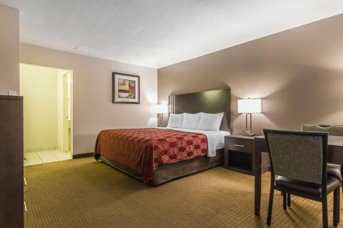 a hotel room with a bed and a chair at Econo Lodge Inn & Suites in Lethbridge