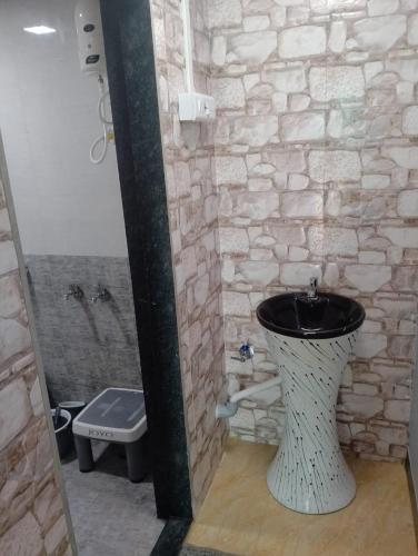 a bathroom with a black and white toilet in it at Wantara resort in Diveagar