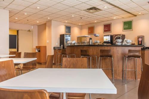 a restaurant with tables and chairs and a bar at Comfort Suites Downtown in Montreal