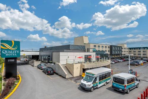 a bus parked in a parking lot in front of a hotel at Quality Hotel Dorval Aeroport in Dorval