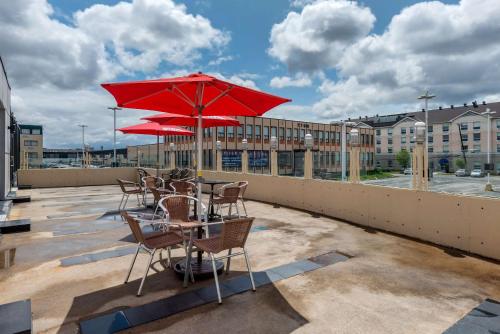 a table and chairs with a red umbrella on a rooftop at Quality Hotel Dorval Aeroport in Dorval