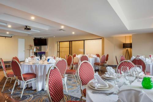 a banquet room with tables and chairs with white tablecloths at Quality Hotel Dorval Aeroport in Dorval