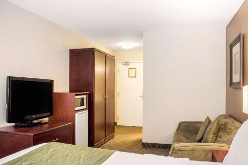 a hotel room with a bed and a flat screen tv at Comfort Inn in Halifax