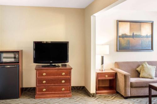 a hotel room with a television and a couch at Comfort Inn in Halifax