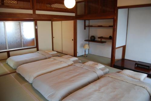 a room with four beds lined up in a room at 一軒宿 百々 private house rental doudou in Mitoyo
