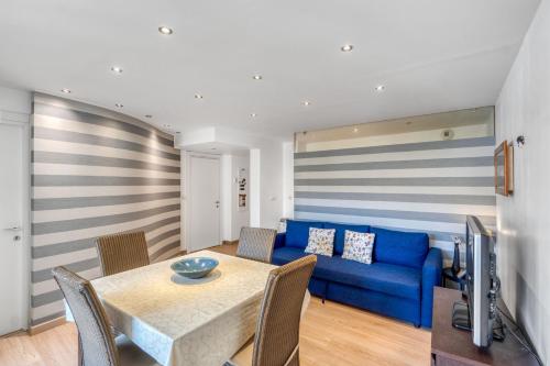 un salon avec un canapé bleu et une table dans l'établissement MC Apartment with Parking, à Beausoleil