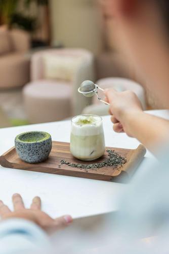 a person with a spoon and a bowl on a table at Andaz Condesa Mexico City, By Hyatt in Mexico City