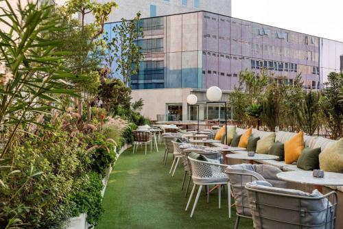 a row of tables and chairs in front of a building at Andaz Condesa Mexico City, By Hyatt in Mexico City