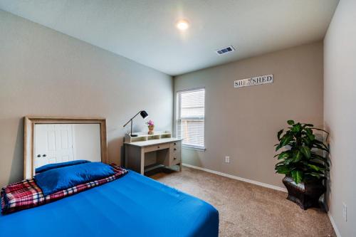 a bedroom with a blue bed and a desk at Rachel's Place in Conroe