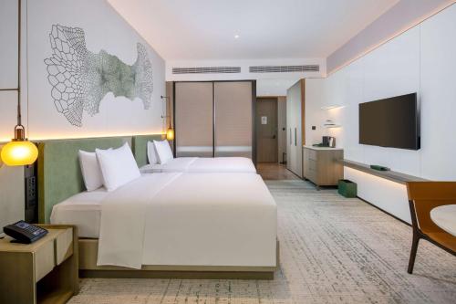 a hotel room with a large bed and a flat screen tv at Doubletree By Hilton Guang'An in Guang'an