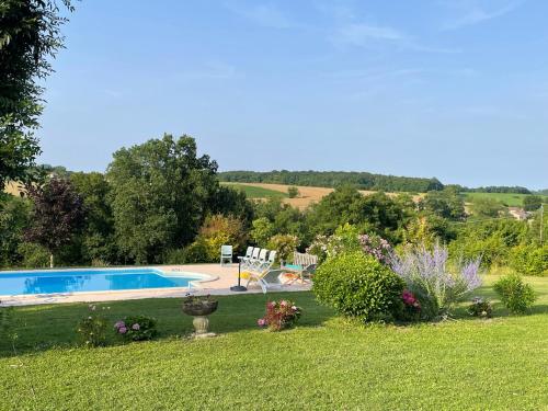 un jardin avec une piscine dans une cour dans l'établissement Gîte Magitte dans son havre de paix, à Bardenac