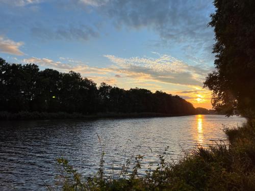 a view of a river with the sun setting at Cozy apartment steps from the spa fountain in Poděbrady