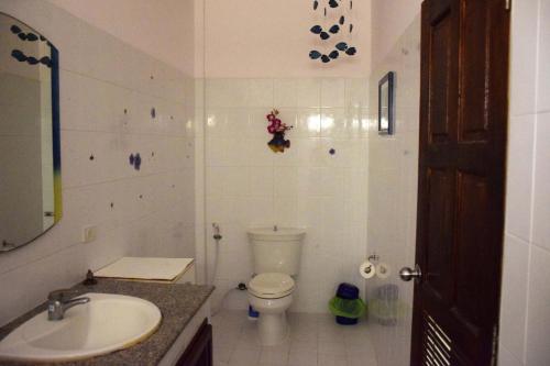 a white bathroom with a toilet and a sink at Sanuk bungalows in Rawai Beach