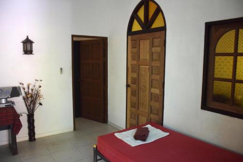 a room with a door and a bed with a towel at Sanuk bungalows in Rawai Beach