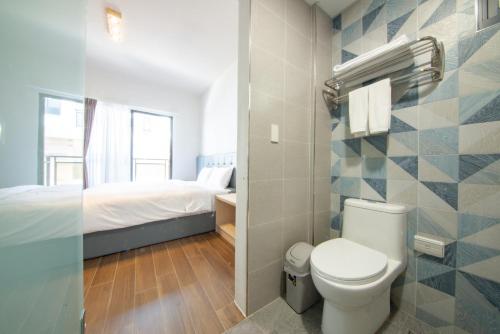 un piccolo bagno con servizi igienici e un letto di Chunzi Apartment B&B a Magong