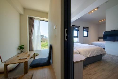 una camera da letto con un letto, una scrivania e un tavolo di Chunzi Apartment B&B a Magong