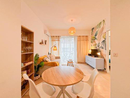 un salon avec une table en bois et des chaises blanches dans l'établissement Plage, Promenade & confort - Wifi, AC, 4 pers, à Nice