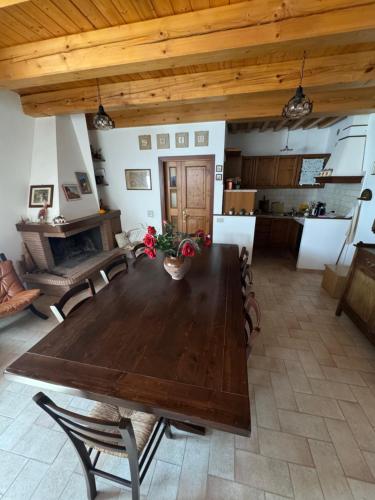 a wooden table and chairs in a living room at Casa Vacanze Emily nel parco del Monte Cucco in Casalvento