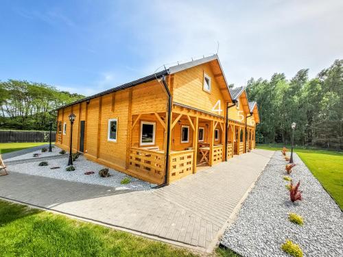 a large wooden building with a courtyard at Starkowo pod lasem in Starkowo